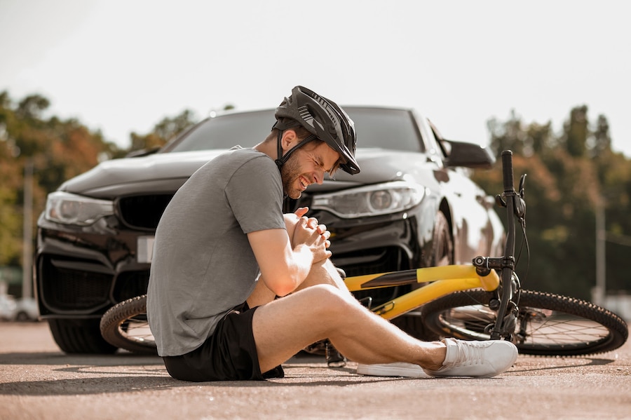 misfortune-unhappy-guy-helmet-sitting-with-closed-eyes-holding-his-knee-n